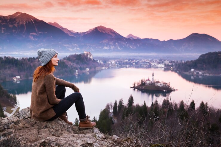 Travel Slovenia Europe Woman looking on Bled Lake with Island Castle and Alps Mountai
