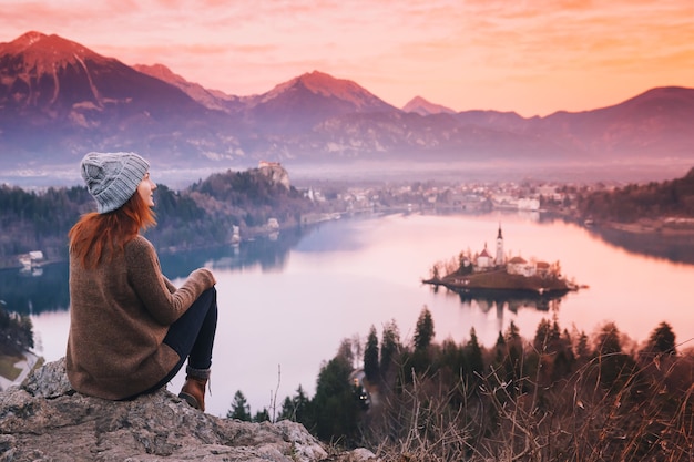 旅行スロベニアヨーロッパ島の城とアルプスmountaiとブレッド湖を見ている女性