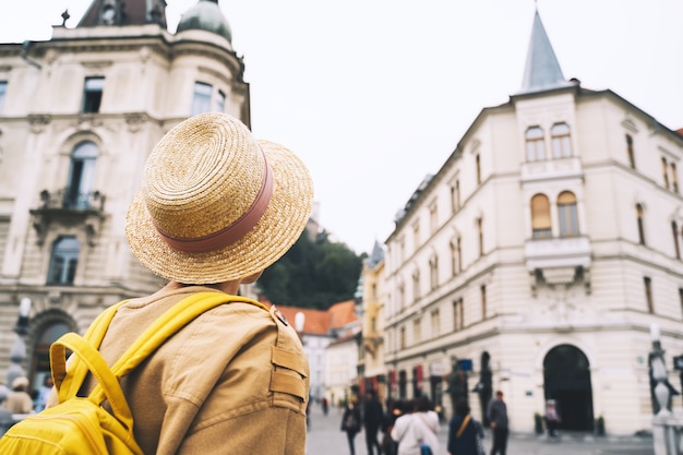 Фото Путешествие словения европа молодая девушка с рюкзаком на тройном мосту в центре старого города любляны