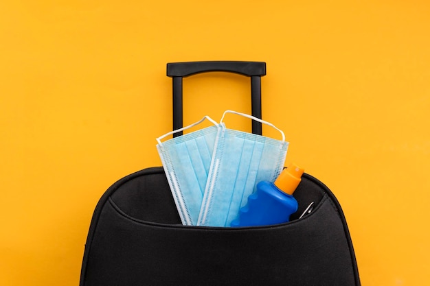 Travel suitcase packed with a face mask and sun cream