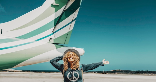 Travel and summer holiday vacation leisure activity woman\
outstretching arms outside the airplane ready to leave or enjoying\
arrival at destination freedom people and happiness with excited\
female