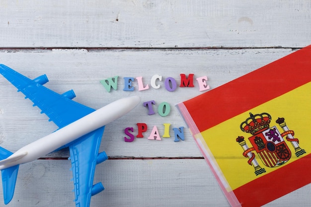 Travel time colorful wooden letters with text Welcome to Spain flag of the Spain airplane model passport