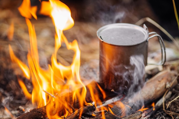 Travel titanium cup on wood on forest background lunch during the journey to the wild