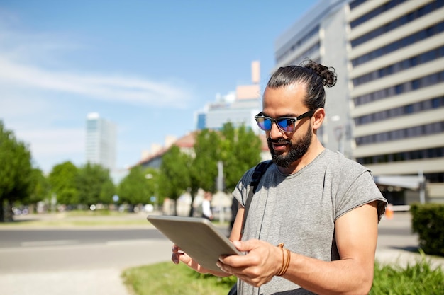 travel, tourism, backpacking, technology and people concept - man traveling with backpack and tablet pc computer in city searching location