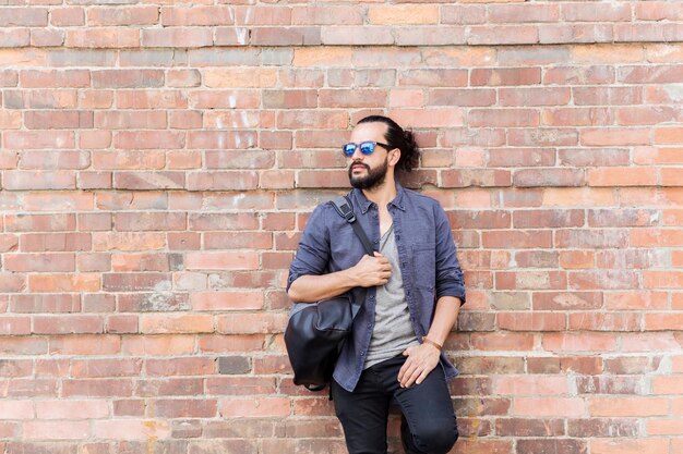 travel, tourism, lifestyle and people concept - happy smiling man with backpack standing at city street wall