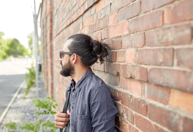 travel, tourism, lifestyle and people concept - man with backpack standing at city street wall