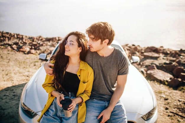 Travel, tourism - Man and woman drink coffee or tea near the car. Couple going on Adventure. Car travel concept.