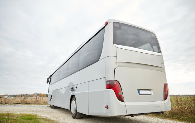 travel, tourism, road trip and passenger transport - tour bus driving outdoors from back