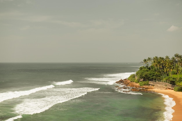 travel, tourism, vacation, seascape and summer holidays concept - sea or ocean waves and blue sky on Sri Lanka beach