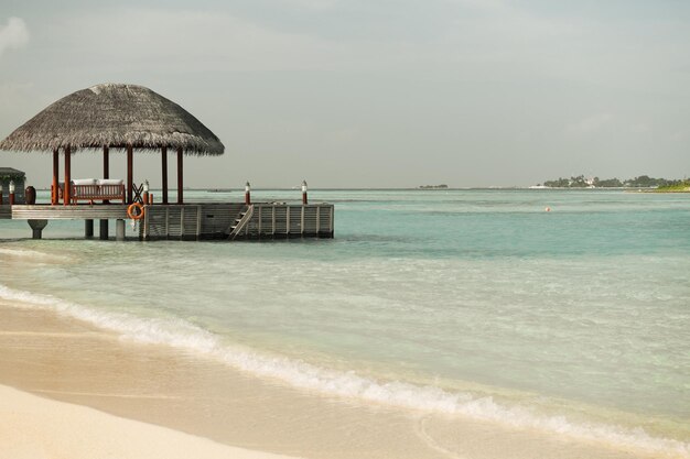 travel, tourism, vacation and summer holidays concept - access to patio or terrace with canopy on maldives beach sea shore