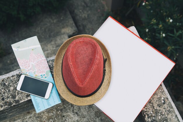 Travel vacation concept Camera phone pizza box map and hat on natural outdoor street background