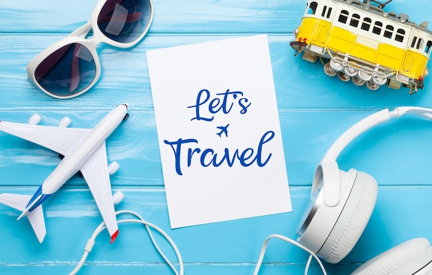 Photo travel and vacation concept trip accessories and items airplane and tram toys sunglasses and headphones top view flat lay