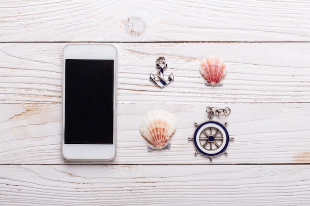Travel vacation concept with sea accessories, smartphone, seashells. Top view with copy space