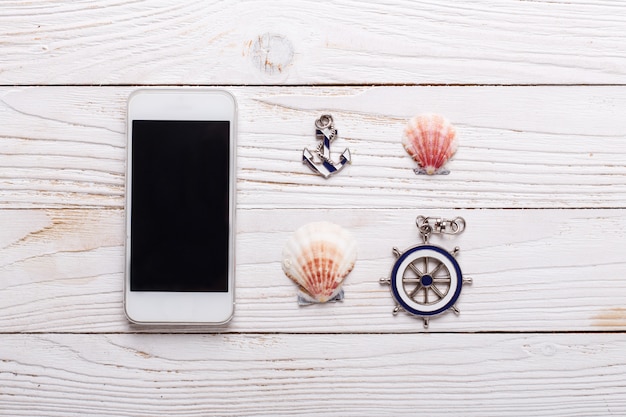 Concetto di vacanza viaggio con accessori mare, smartphone, conchiglie. vista dall'alto con lo spazio della copia