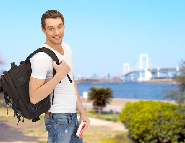 travel, vacation and education concept - travelling student with backpack and book