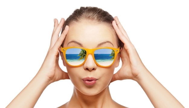 travel, vacation, summer holidays and happy people concept - portrait of amazed teenage girl in sunglasses with beach reflection