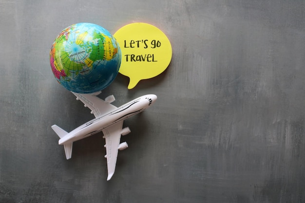 Travel and vacation toy plane earth globe and note paper with\
text let\'s go travel copy space