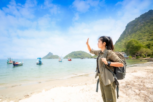 海に広げられた旅行の女性の腕