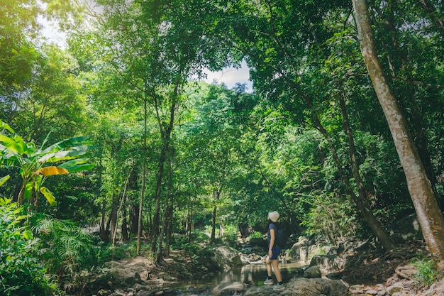 Женщина путешествует по скале, путь к водопаду в природном парке
