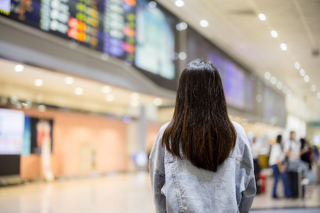 旅行の女性画面のフライトスケジュールを見て