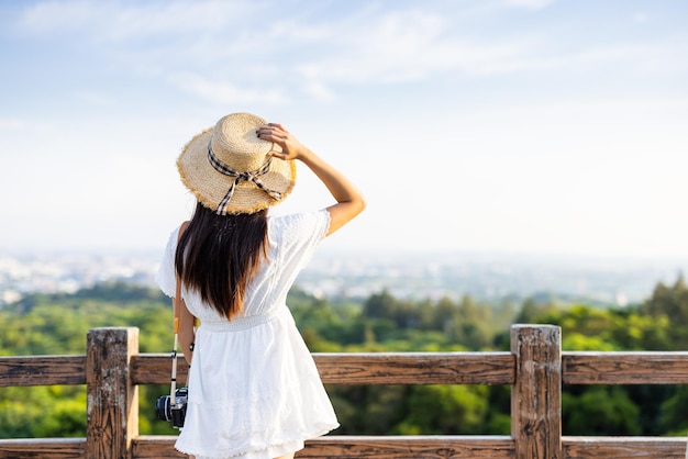 旅する女性は街の外を見て山を見ます