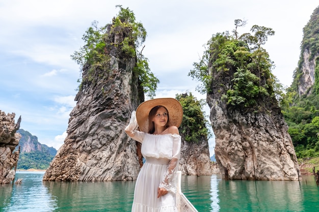 Travel woman sitting on boat near famous three rocks in khao sok park thailand