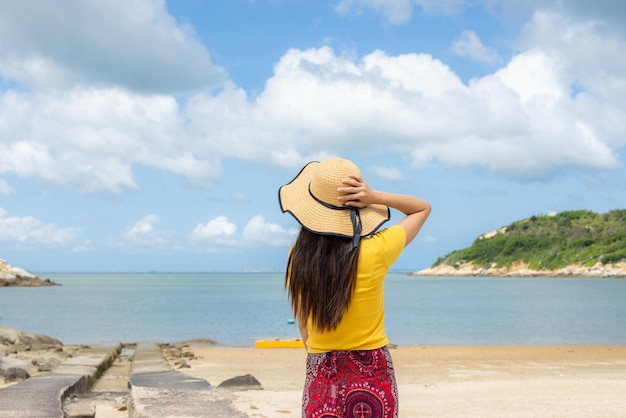 旅行の女性がビーチを散歩している