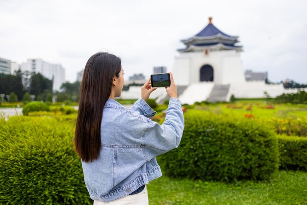 台湾のチアンカイシェク記念ホールで携帯電話で写真を撮る女性旅行者