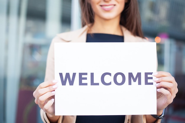 Travel. women business with the poster with welcome
message.