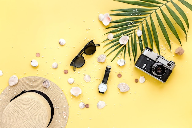 사진 팜 리프 카메라와 선글라스가 있는 노란색 배경의 여행자 액세서리 평평한 평면도 여름 배경