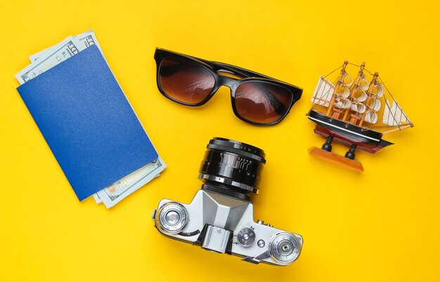 Photo traveler accessories, retro camera on yellow. flat lay