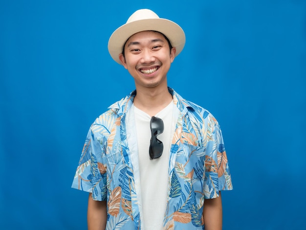 Traveler asian man wear hat with sunglasses happy smile blue background