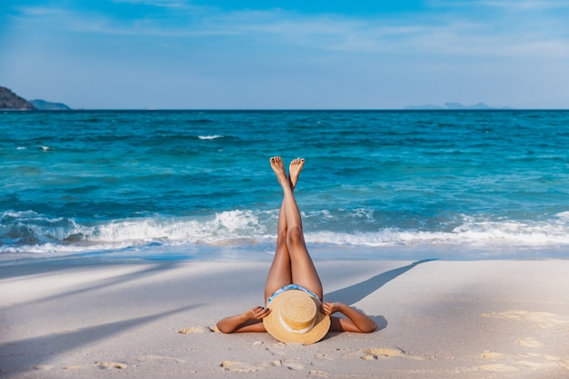 Foto donna asiatica del viaggiatore con il bikini ed il cappello che si rilassano sulla spiaggia del mare al giorno in koh lipe, satun, thailand