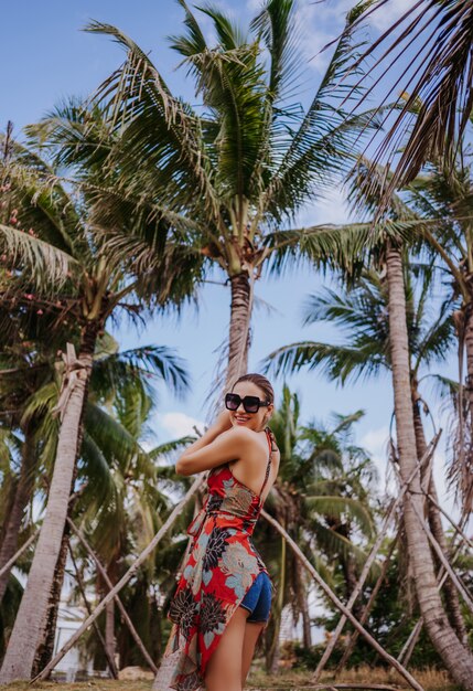 Traveler blonde beautiful woman in sunglasses walking in jungle tropical park. Travel adventure nature in China, Tourist beautiful destination Asia, Summer holiday vacation journey trip concept