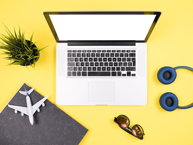 Traveler businessman top view yellow desk concept image,sunglasses, headpphones, pot of grass