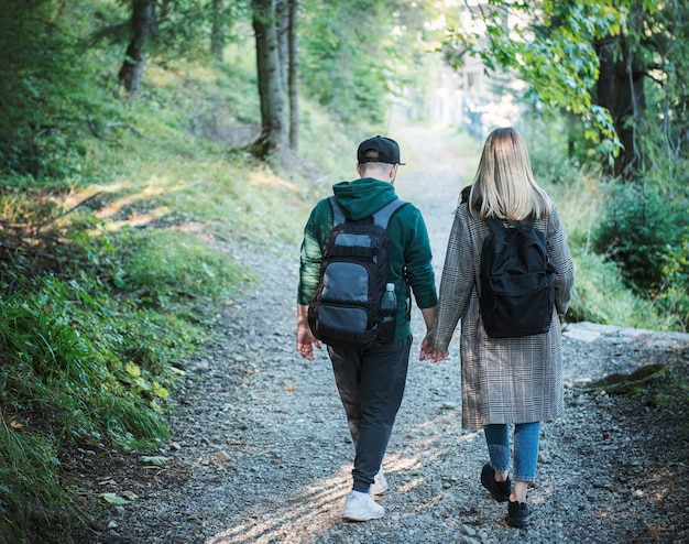 Coppia di viaggiatori innamorati che si godono nella foresta. libertà e concetto di stile di vita attivo. vista posteriore