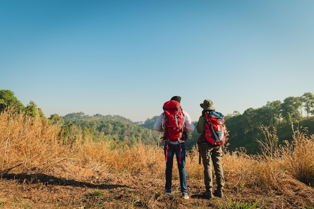 Traveler couple with backpack standing looking view on mountain