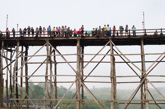 Traveler crossing or Mon Bridge in Sangklaburi. Kanchanaburi, Thailand.