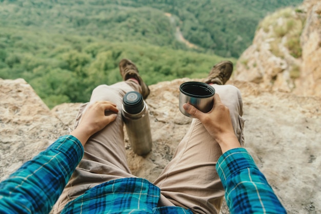 Foto viaggiatore che beve tè dal thermos