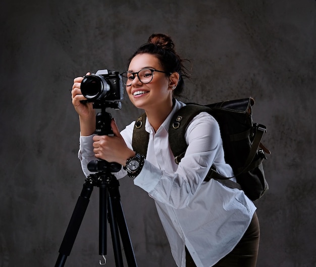 Traveler female taking pictures with a digital camera on a tripod.