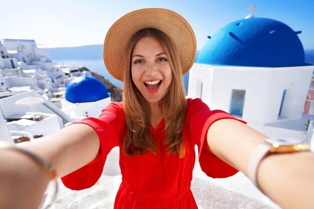 Photo traveler girl taking a selfie on her vacation in santorini greece