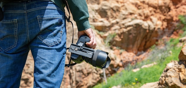 岩壁の旅行者の手の写真カメラ