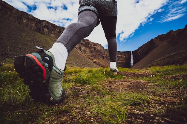 Traveler hiking at hengifoss waterfall, iceland.