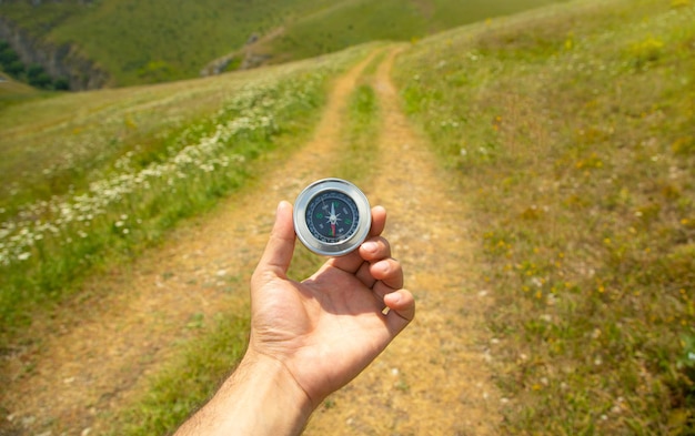 Traveler holding compass in nature background