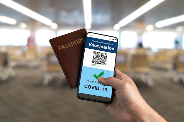 Traveler holds vaccine passport certificate to show COVID 19 vaccination status