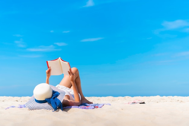 여름 휴가 열 대 해변에서 책을 읽고 읽는 여행자