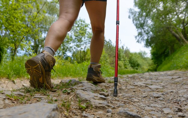 Foto le gambe del viaggiatore, la donna sta camminando sul sentiero