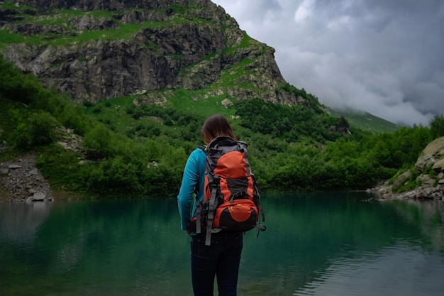Путешественник смотрит на горное озеро Концепция путешествий и активной жизни