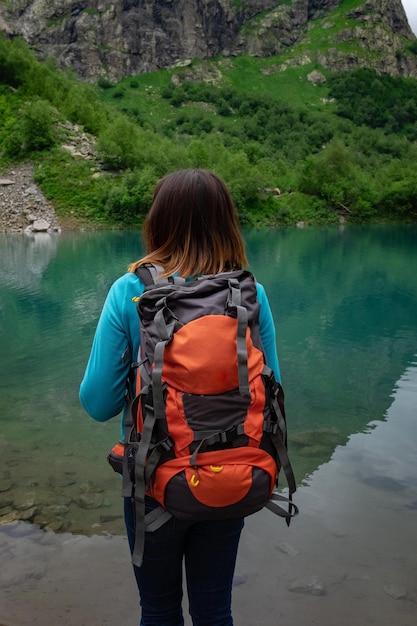 旅行者は山の湖を見て旅行とアクティブライフのコンセプト