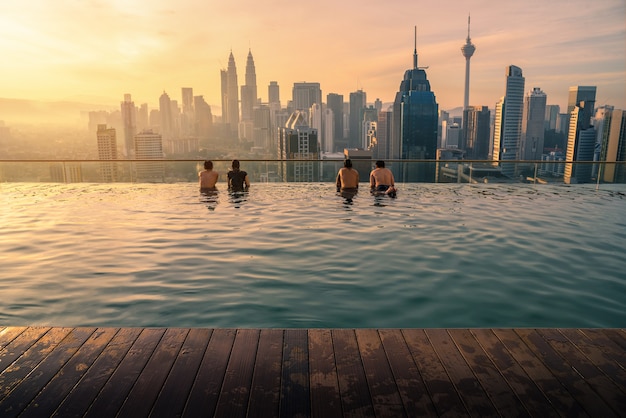 Traveler looking view skyline Kuala Lumpur city in swimming pool in Kuala Lumpur, Malaysia